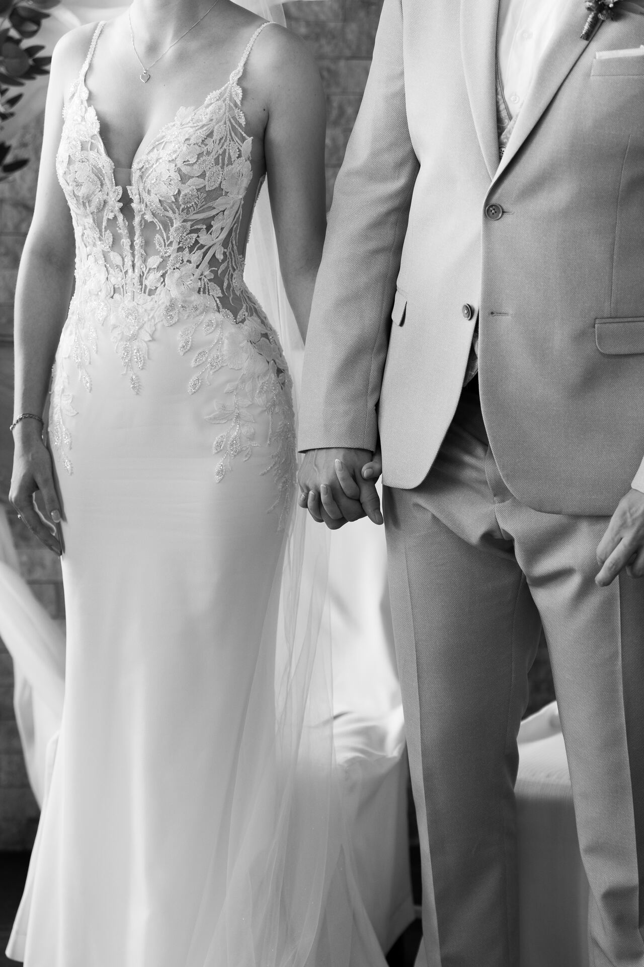 Brautkleid und Anzug, Hand in Hand, Schwarzweiß